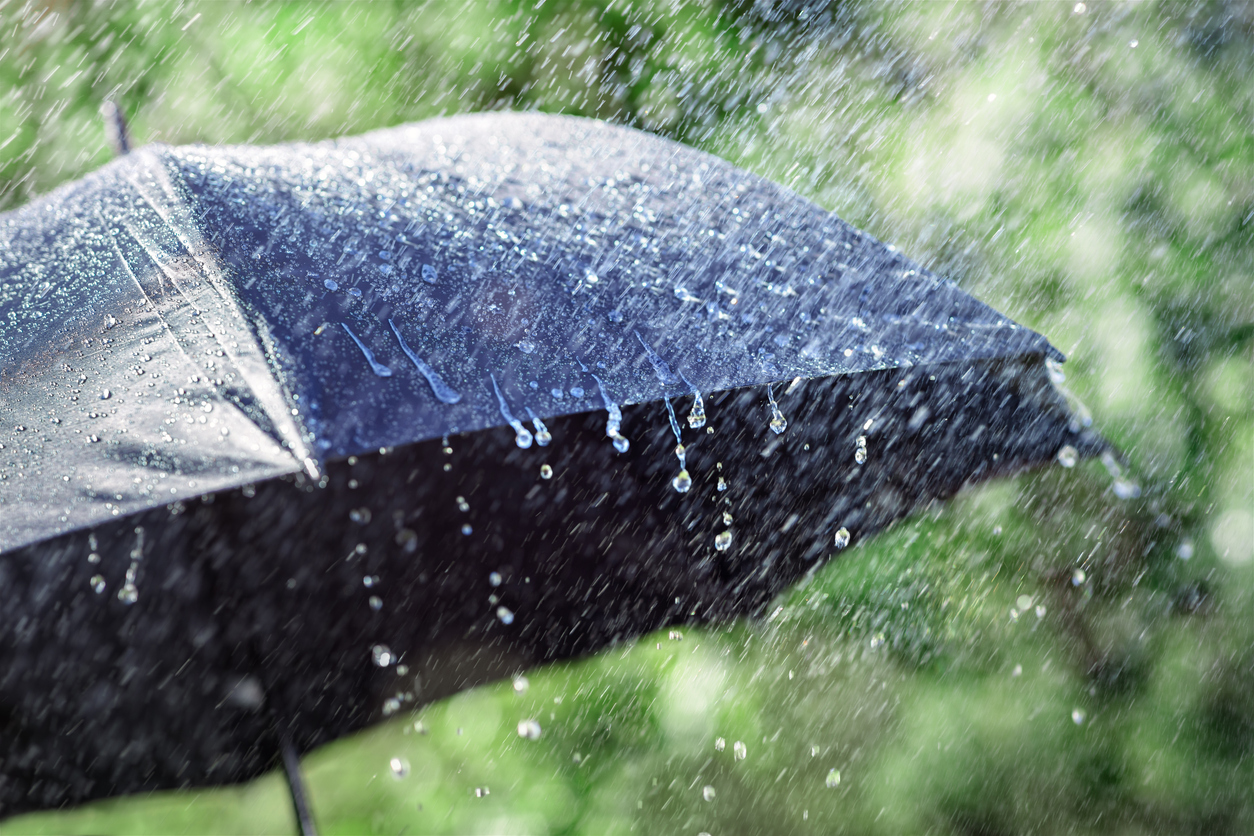 Umbrella with heavy rain beating down on it
