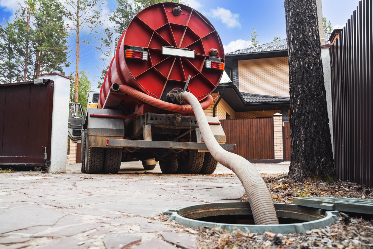 Septic pumping truck servicing a residential septic tank